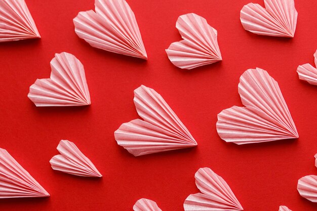 Walentynki leżały płasko Stylowa kompozycja różowych serc na tle czerwonego papieru Szczęśliwych walentynek Nowoczesne słodkie wycięcia walentynkowe serca Kreatywny transparent miłosny