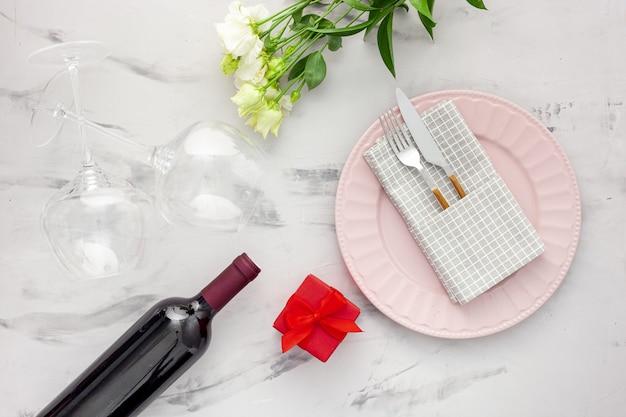 Walentynki nakrycie stołu z talerzem, winem i kieliszkami