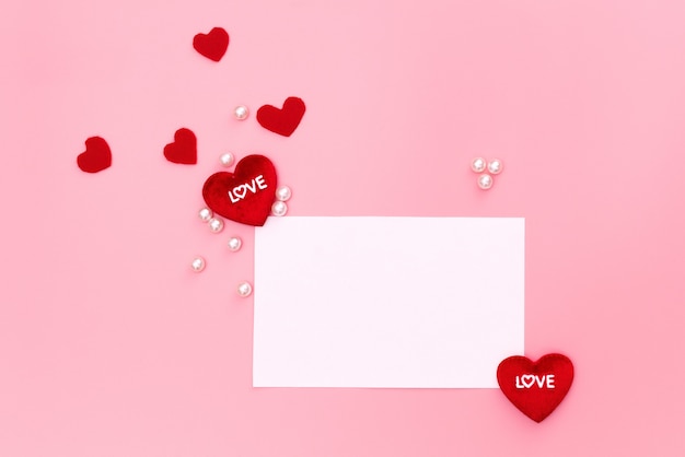 Walentynki pojęcie, czerwoni serca i biel notatka na różowym tle