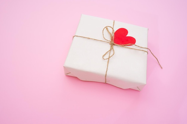 Walentynki prezent na różowym tle z czerwonymi sercami domowej roboty koncepcja miłości walentynki