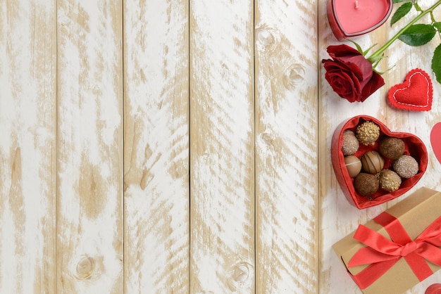 Walentynki romantyczna dekoracja z różami i czekoladą na białym drewnianym stole. Widok z góry, miejsce.
