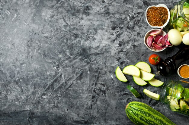 Warzywa . Świeże warzywa (ogórki, pomidory, cebula, czosnek, koperek, fasolka szparagowa) na szarym tle. Widok z góry. copyspace