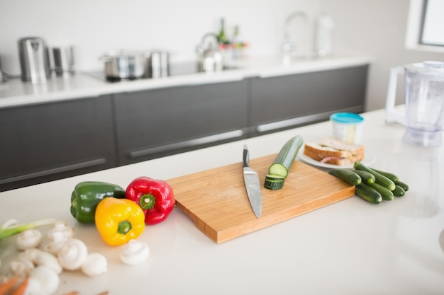 Zdjęcie warzywa z nożem i deską do krojenia na blacie kuchennym