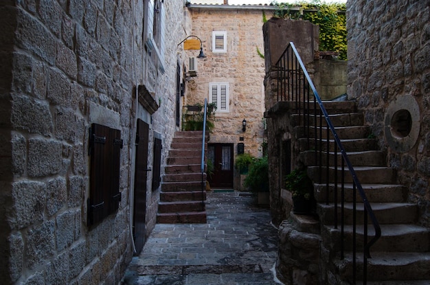 Wąskie schody uliczne stare miasto i zabytkowa latarnia na ścianie w ciągu dnia