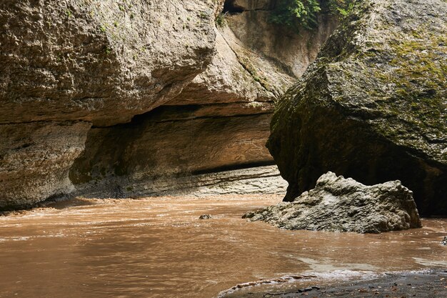 Wąwóz górski z błotnistą rzeką podnoszącą się podczas powodzi po deszczu