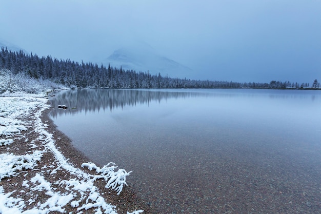 Wczesna zima z pierwszym śniegiem pokrywającym skały i lasy w Parku Narodowym Glacier, Montana, USA