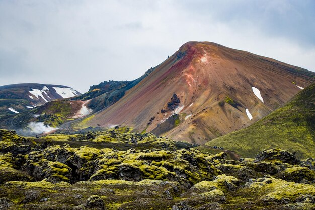 Wędrówki po górach ze śniegiem, zielonym mchem wulkanicznym, kolorową górą, Landmannalaugar, Islandia