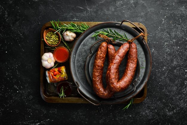 Wędzony domowy pierścionek z kiełbasą Kiełbasa na czarnym kamiennym tle Widok z góry