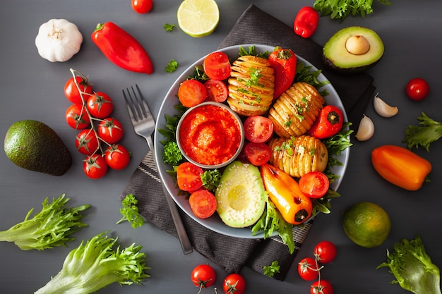 Wegańska miska Buddy. zdrowa miska na lunch z ziemniakiem hasselback, awokado, pomidorem, papryką i sosem pieprzowym