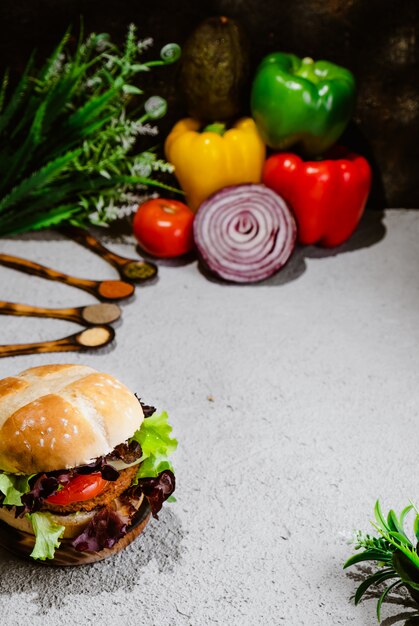 Wegański burger na drewnianej powierzchni z warzywami. Zdrowe wegańskie jedzenie. Seitan, soja