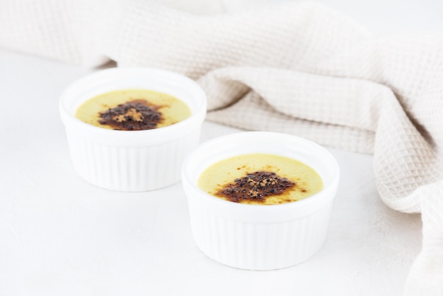 Wegański creme brulee z jagodami w miskach na stole.