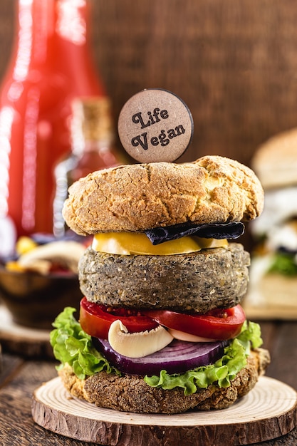 Wegański hamburger z hamburgerem na bazie soi. Drewniany napis w języku angielskim: Vegan Life
