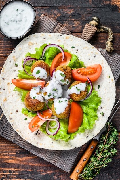 Wegetariański falafel z warzywami i sosem tzatziki na tortillowym chlebie