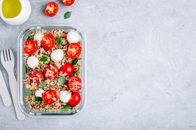 Wegetariańskie pojemniki na lunch do przygotowywania posiłków z pomidorami z serem quinoa mozzarella i bazylią Przestrzeń kopii w widoku z góry