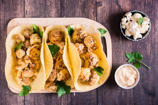 Wegetariańskie tacos z kalafiorem i ziołami na desce na stole Domowe jedzenie Widok z góry