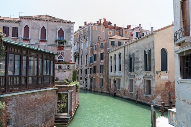 Wenecja, Włochy - 1 lipca 2018: Panoramiczny widok na wąski kanał Wenecji z zabytkowymi budynkami i ruchem łodzi z mostu. Krajobraz letniego słonecznego dnia