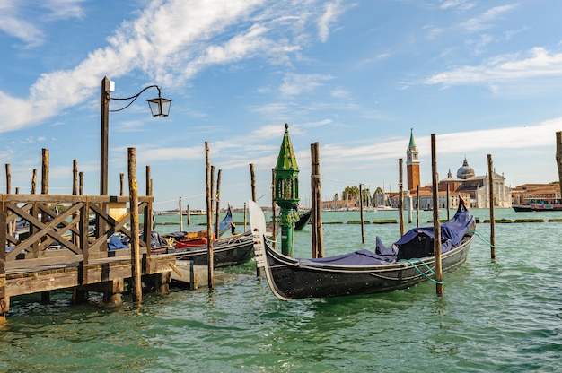 Wenecja, Włochy - wrzesień: gondole zaparkowane w Canal Grande, w pobliżu placu San Marco z kościołem San Giorgio di Maggiore w tle