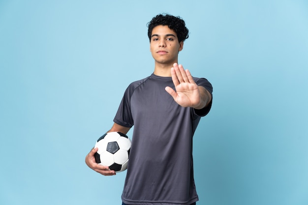 Wenezuelski piłkarz mężczyzna na białym tle robi gest stop