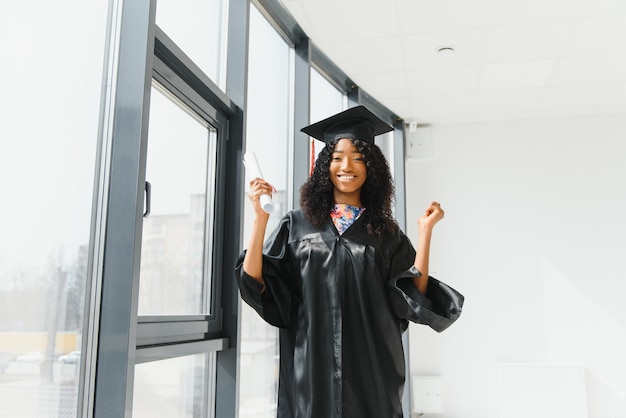 Wesoła afroamerykańska absolwentka z dyplomem w ręku