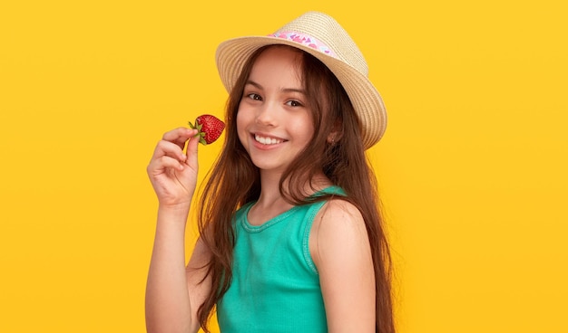 Wesoła dziewczyna ciesząca się truskawkami i uśmiechnięta