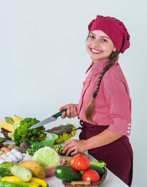 Wesoła dziewczynka gotuje sałatkę witaminową z warzyw organicznych