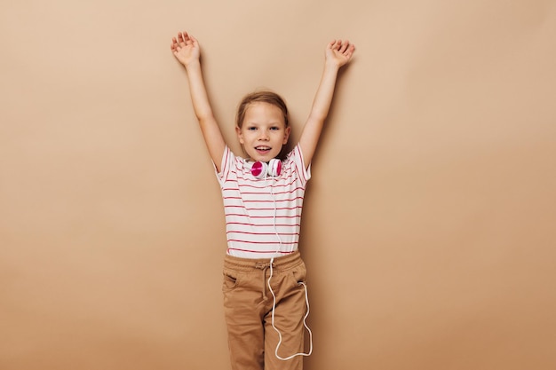 Wesoła dziewczynka słucha muzyki przez słuchawki dzieciństwo zabawy