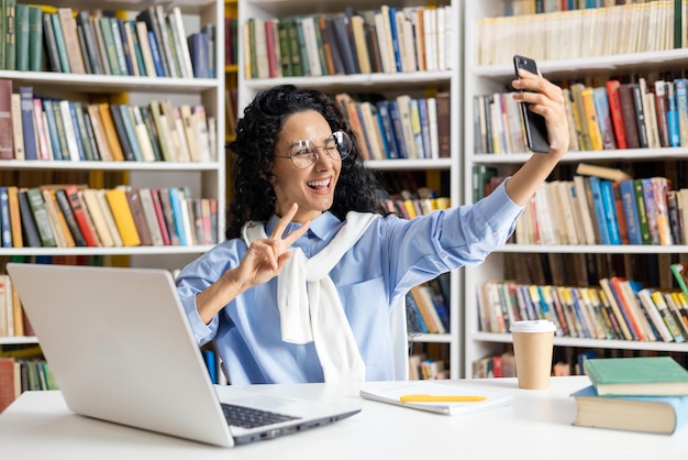 Wesoła Hiszpańska Studentka Robi Zabawne Selfie Wśród Książek W Bibliotece