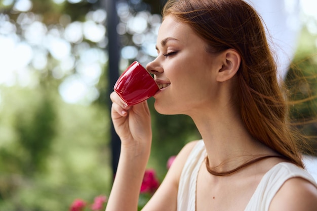 Zdjęcie wesoła kobieta pijąca kawę na świeżym powietrzu szczęśliwa kobieta relaksująca się zdjęcie wysokiej jakości