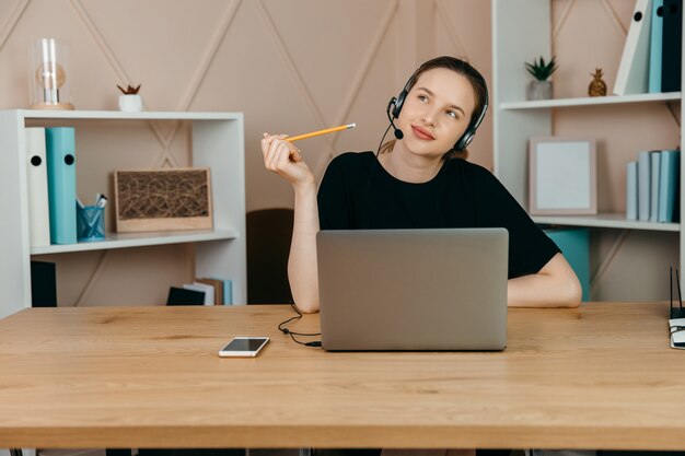 Wesoła kobieta pracuje na laptopie