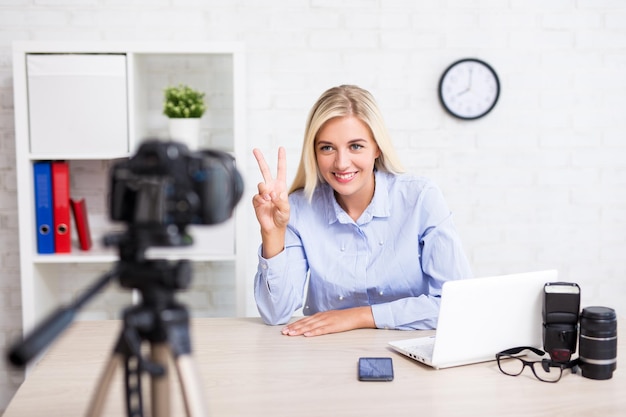 Wesoła kobieta wideo blogerka opowiadająca o fotografii i wideografii