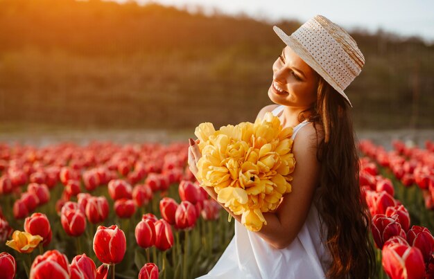 Wesoła kobieta z bukietem w polu tulipanów