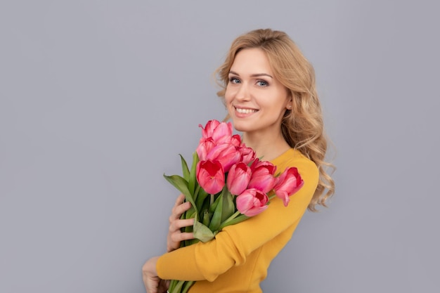 Wesoła kobieta z tulipanami pani trzyma kwiaty na wiosenne wakacje dziewczyna z bukietem