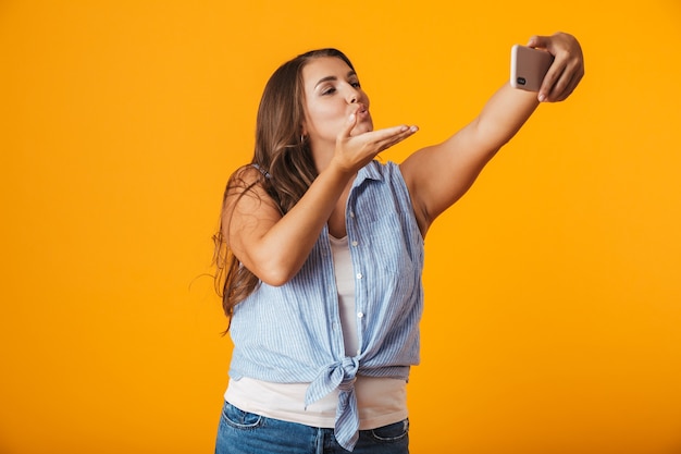 Wesoła Młoda Kobieta, Biorąc Selfie Z Wyciągniętą Ręką