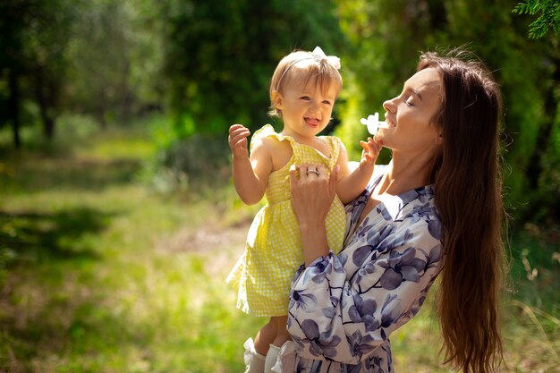 Wesoła młoda mama bawi się z córeczką w ogrodzie