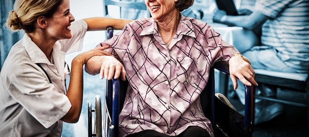 Wesoła Niepełnosprawna Starsza Kobieta Siedząca Na Wózku Inwalidzkim, Patrząca Na Lekarkę