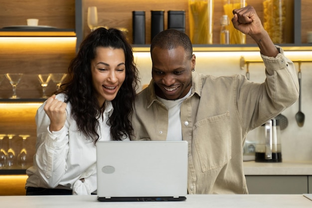 Wesoła para szczęśliwie wygrywa na loterii w laptopie w domu