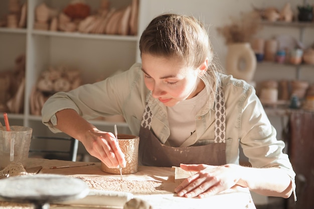 Wesoła piękna kobieta ciesząca się pracą z gliną na zajęciach plastycznych