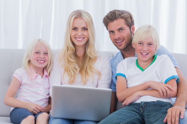 Wesoła rodzina za pomocą laptopa