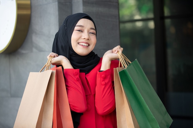 wesoła szczęśliwa kobieta ciesząca się zakupami niesie torby na zakupy