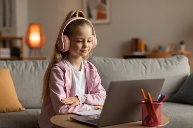 Wesoła Uczennica Uczy Się Online Na Laptopie Oglądając Zajęcia Na Odległość W Pomieszczeniu