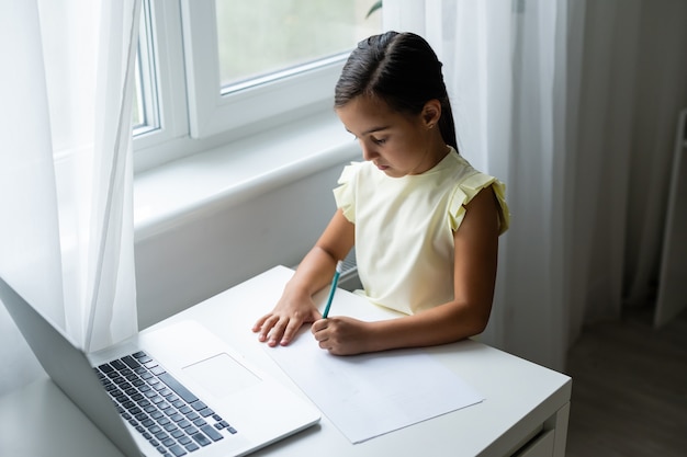 wesołe małe dziewczynki korzystające z laptopa, uczące się przez internetowy system e-learningowy