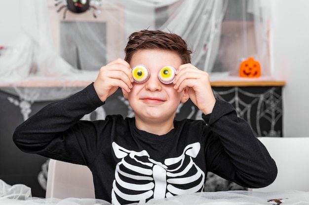 Wesołego Halloween! Atrakcyjny Młody Chłopak W Kostiumie Bawi Się I Bawi Się Przerażającą Dekoracją Oczu