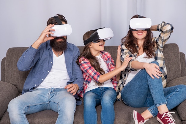 Wesoli rodzice z dzieckiem spędzają razem czas w okularach vr w domu wirtualnej rzeczywistości