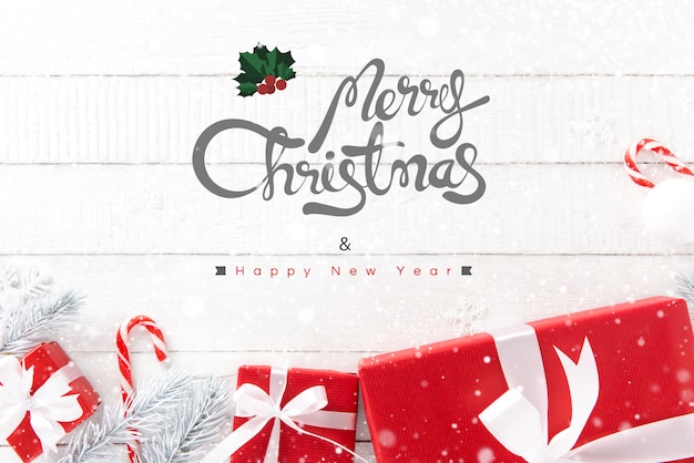 Wesoło boże narodzenia i Szczęśliwy nowego roku tekst z czerwonymi prezentów pudełkami i ornamentami na białym drewnianym tle