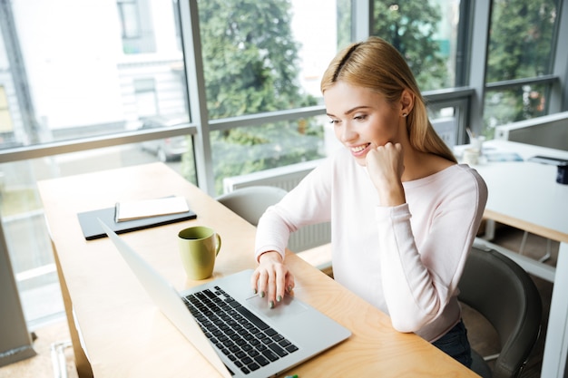 Wesoły Dama Siedzi W Biurze Coworking