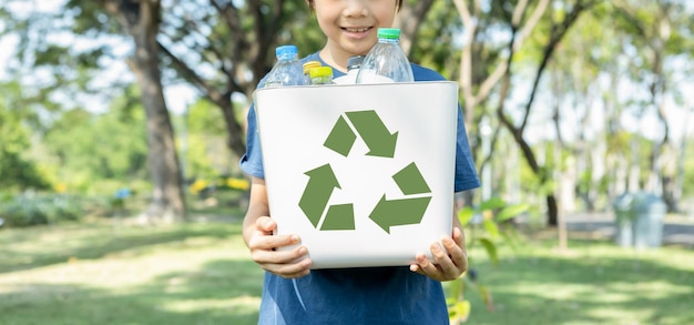 Wesoły młody azjatycki chłopiec trzymający symbol recyklingu.