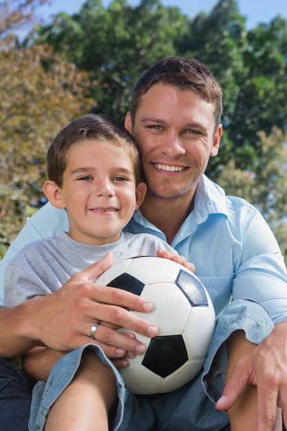Wesoły tata i syn z piłką nożną