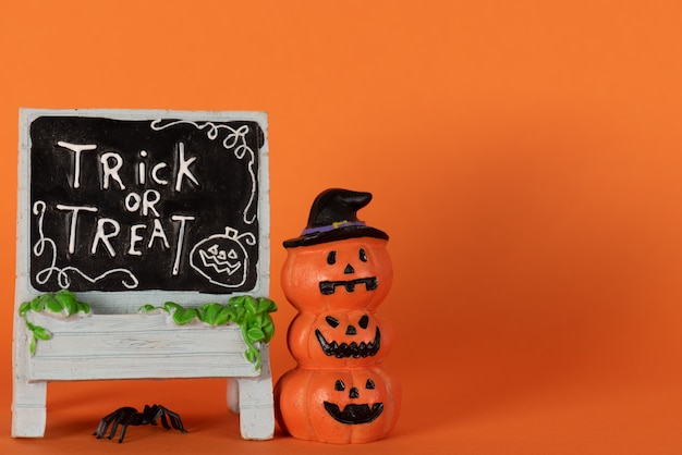 Zdjęcie wesołych świąt halloween, cukierek albo psikus z dyni i pająka na pomarańczowo