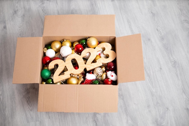 Wesołych Świąt i Szczęśliwego Nowego Roku Przygotowanie do święta Pudełko z zabawkami na choinkę i cyframi 2023 wykonane z drewna Miejsce na tekst