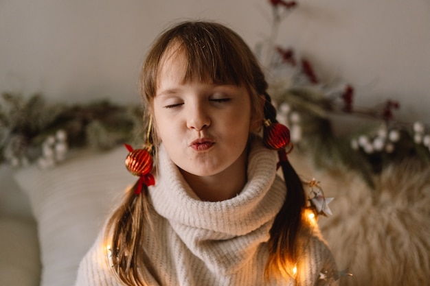 Wesołych Świąt i Wesołych Świąt. Dziewczyna daje pocałunek powietrza. Czekając na Boże Narodzenie.